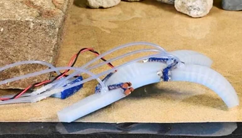 An x-shaped robot severs one of its own "limbs" after its trapped under a fallen brick.