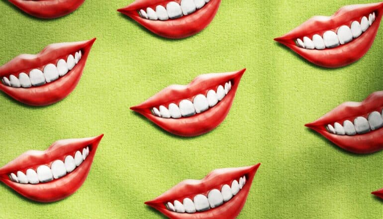 Rows of smiles with red lips and white teeth sit on a green fabric background.