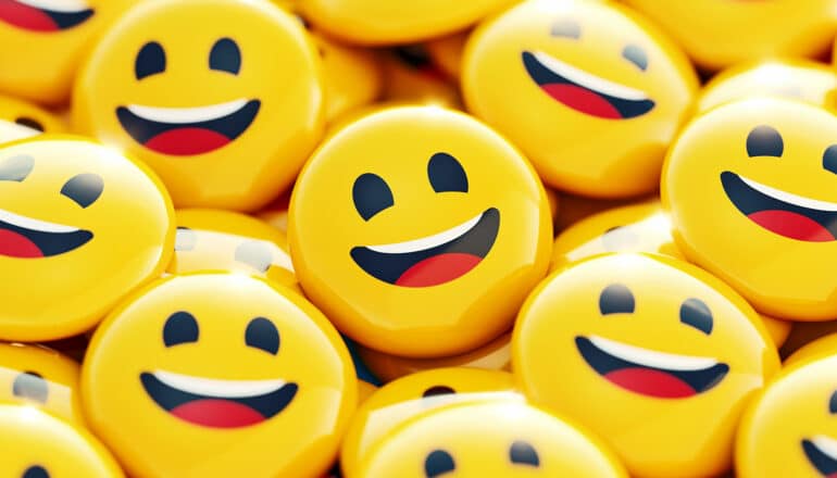 Buttons with smiley faces on them sit in a pile.