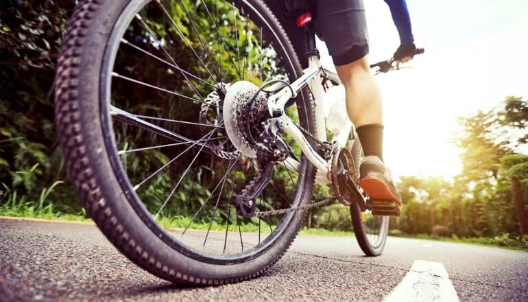 A person rides a bike on a rural road.