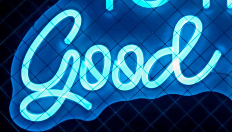 A blue neon sign of the word "good."