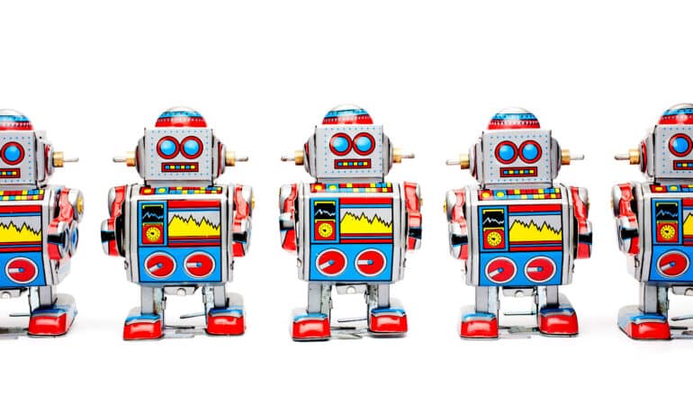 A row of toy robots on a white background.