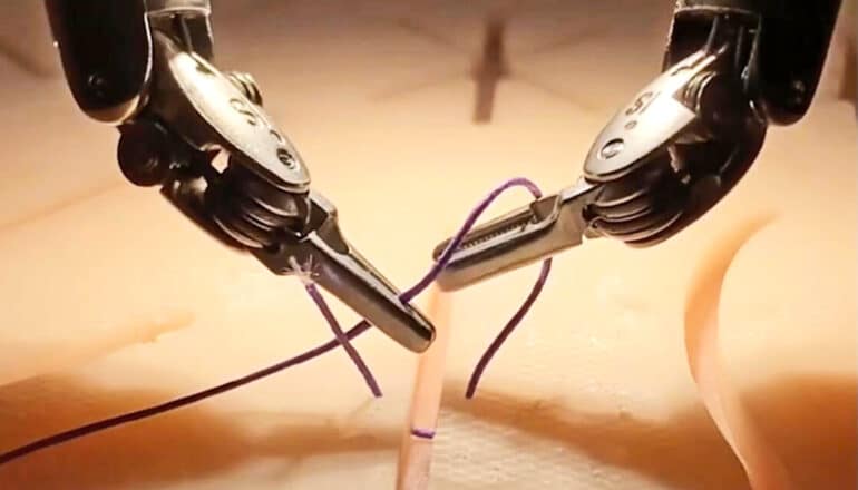 Two robot hands hold onto a suture during a practice session.