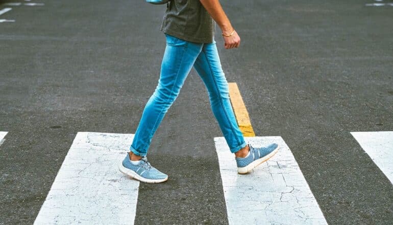 A person walks on a city crosswalk.