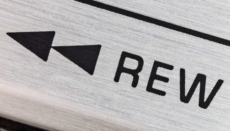 A close-up shot of a rewind button on a tape player.