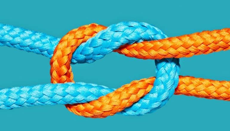 A knot between a blue and orange rope.