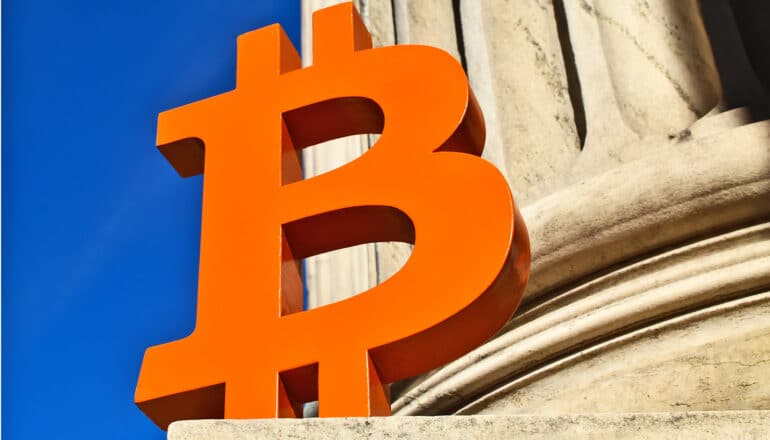 A large orange version of Bitcoin's logo, which is a letter B with two lines through it.