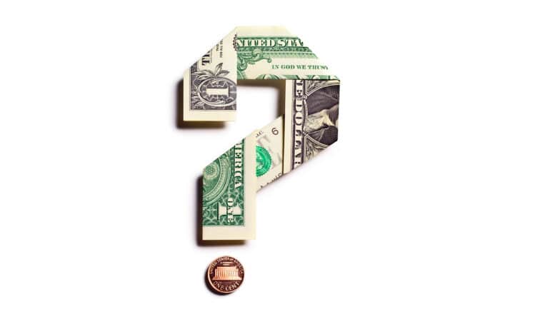 A dollar bill folded into the shape of a question mark with a penny as the dot at its bottom.