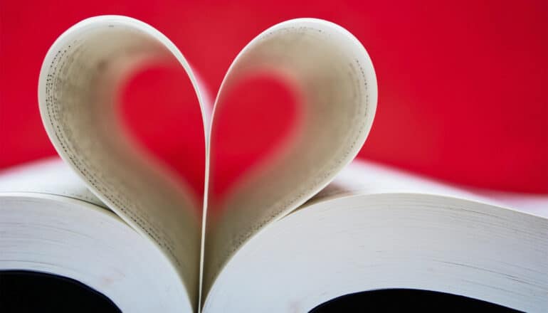 A book with pages at the center curled to look like a heart.